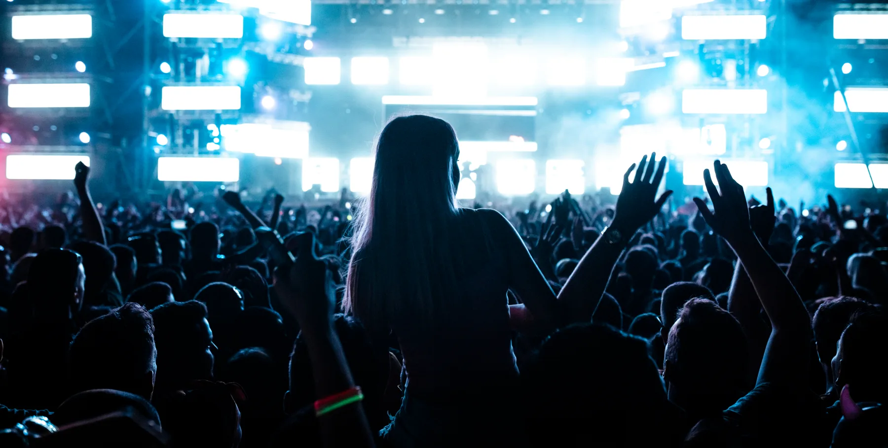 Público frente al escenario iluminado de un festival de música